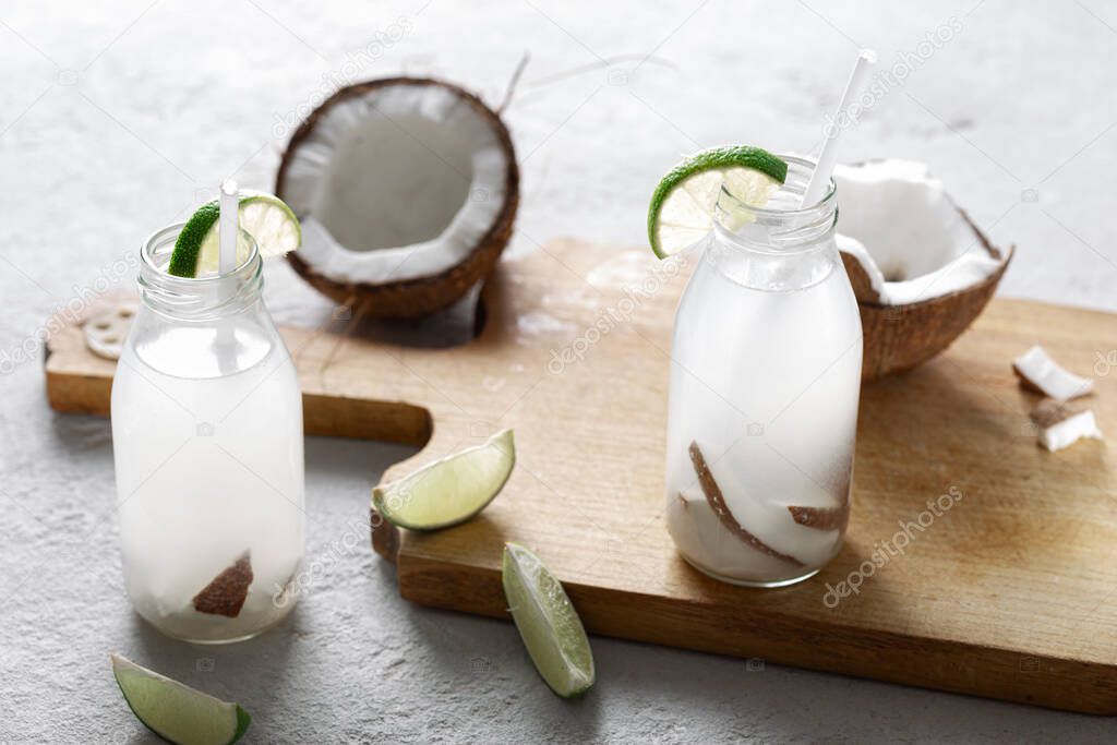 Coconut water in bottles on light background. Healthy veggie drink