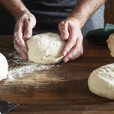 Pastanede ekmek için hamur hazırlayan adam.