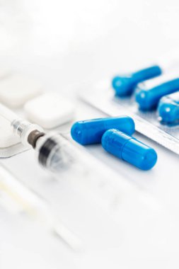 Eczacılık antibiyotik kapsül hapları şırınga ve termometre ile beyaz arka planda fotokopi alanı ile