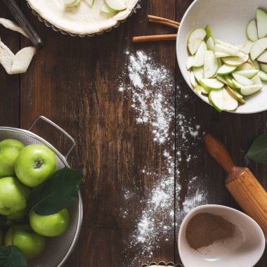 Ahşap bir masada elmalı turta pişirmek için gerekli malzemelerin çerçevesi.