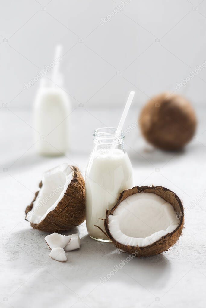 Coconut milk in bottles on light background. Vegan non dairy healthy drink. Healthy eating concept