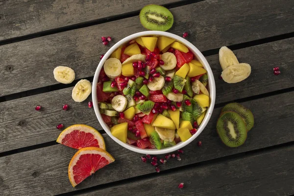 Gemengde Fruitsalade Plaat Houten Achtergrond Bovenaanzicht Dieet Zomerkeuken Concept — Stockfoto