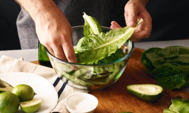 Sağlıklı beslenme konsepti. Yeşil sebze salatası pişiren adam.