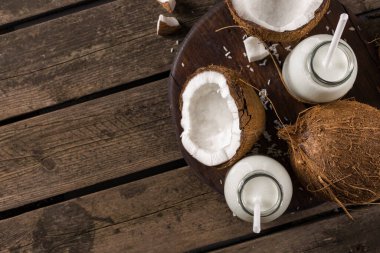 Tahta masadaki şişelerde hindistan cevizi sütü. Vegan sütsüz sağlıklı içecek. Sağlıklı yeme kavramı