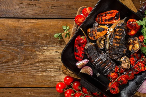 Ahşap arka planda ızgara tepsisinde pişirmek için çeşitli sebzeler kopya alanı