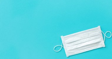 Mavi arkaplanda koronavirüse, virüse veya kirliliğe karşı mavi maske koruması
