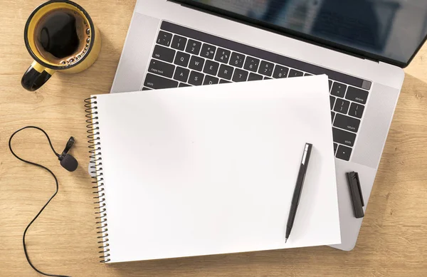 オンライン教育の概念木製のテーブルの上にノートパソコン カップコーヒーとマイクと空白のノートブックビュー — ストック写真