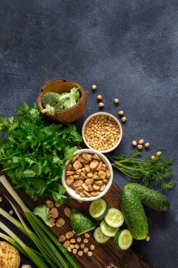 Sağlıklı yiyecekler temiz yeme konsepti. Yeşil sebzeler, otlar, mısır gevreği ve fındıklar.