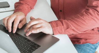 Merkez ofiste dizüstü bilgisayarla çalışan bir adam. Ev ofisi kavramında çalış