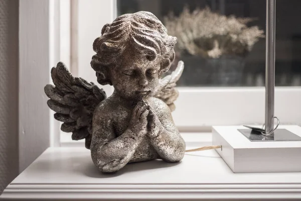 angel figurine standing on the windowsill