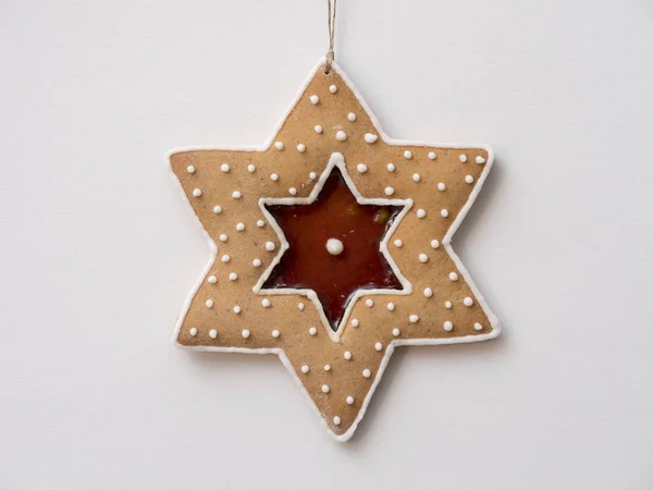 白い背景に色のアイシングで飾られたクリスマスの星型のジンジャーブレッド — ストック写真