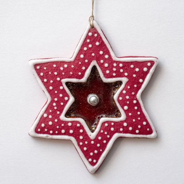 Christmas star-shaped gingerbread decorated with coloured icing in the white background