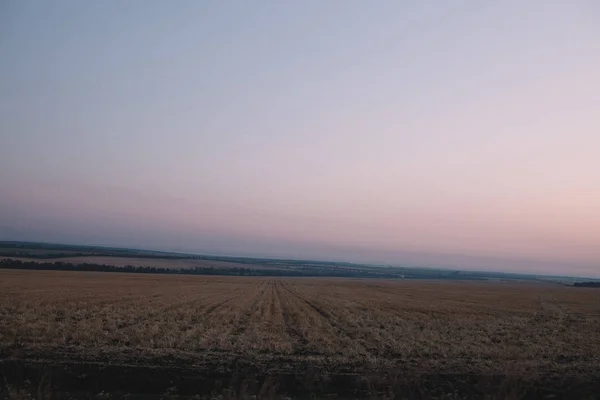 Sonnenaufgang auf einem Feld inmitten der Hügel — Stockfoto