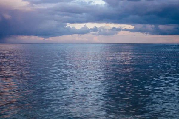 Vista panorámica de la costa del mar con piedras y nubes de trueno borrosas — Foto de Stock