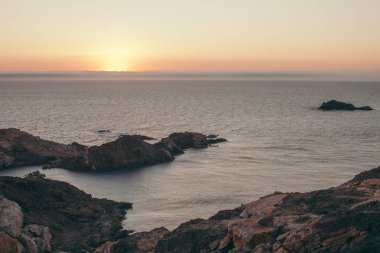 Deniz koyunda gün doğumunda kayalar