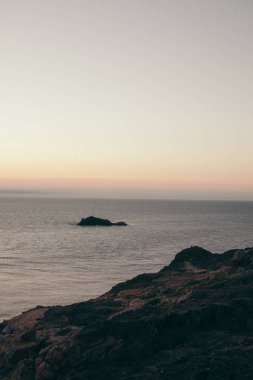 Deniz koyunda gün doğumunda kayalar