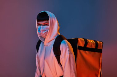 Beyaz elbiseli, sarı sırt çantalı bir teslimatçı.