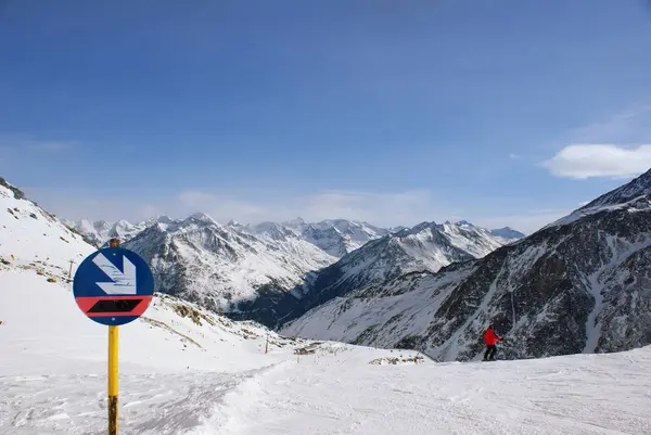 Señal de descenso en las laderas de las montañas alpinas, la persona va a bajar a esquiar, muchos picos de montaña por delante —  Fotos de Stock