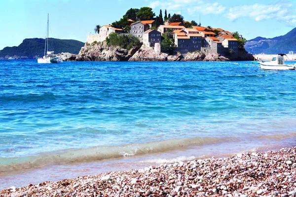 Montenegro's a major tourist attraction - the island of Sveti Stefan left the beach, the blue crystal clear sea, yachts — Stock Photo, Image