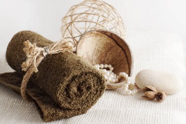 Bir rulo havlu ve bir ışık dokuma peçeteye Hindistan cevizi, bir spa yordam için hazırlık içinde inci.