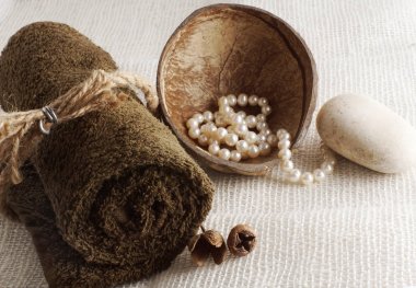 Rulo havlu, bağlı bir ip ve bir ışık dokuma peçeteye Hindistan cevizi, bir spa yordam için hazırlık içinde inci ile.