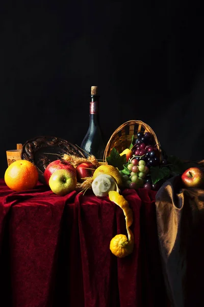 Natura morta olandese classica con bottiglia polverosa di vino e frutta su sfondo scuro — Foto Stock