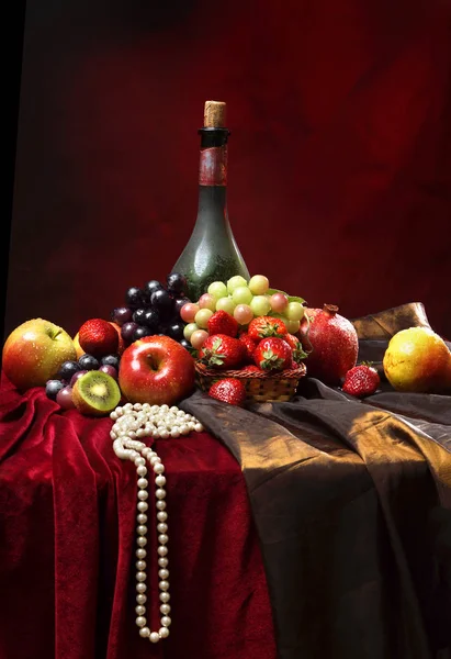 Perles perlées se trouvent sur le bord de la table, nature morte hollandaise classique avec bouteille poussiéreuse de vin et de fruits sur un fond rouge foncé, verticale — Photo