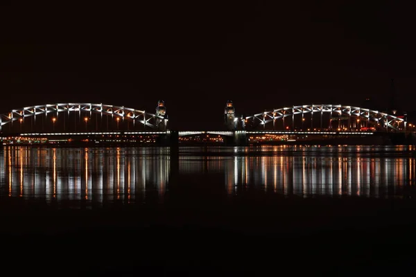 Zugbrücke in St. petersburg, beleuchtet von Lichtern und reflektiert in der Newa — Stockfoto