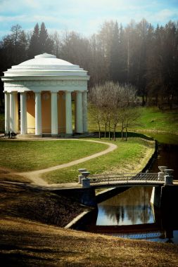 Güzel bir park ile yolları ve bir köprüden diğer tarafa bir akışı, dikey sütunlara ile beyaz klasik çardak