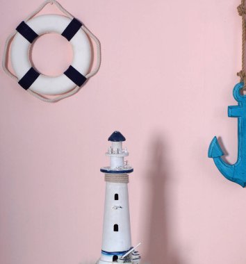Kompozisyon bir deniz tarzı. Oyuncak daire ve bir duvar pembe renk çapa bekle, gölgeni deniz feneri yan yana duruyor.