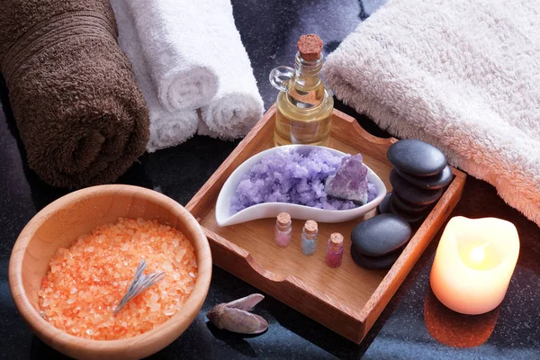 Set para procedimientos de spa con sal de diferentes colores, piedras calientes con aceite aromático y toallas suaves . — Foto de Stock
