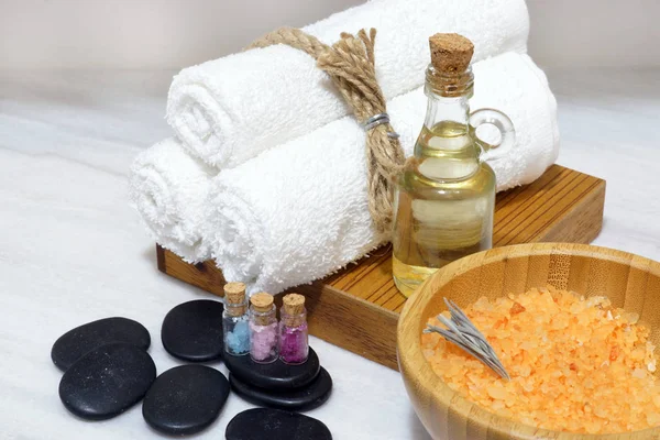 Spa yordamlar için bir küme bir aromatik yağ, yumuşak havlu, sıcak taşlar ve banyo tuzu kaşıkla ahşap bir kasede makyaj