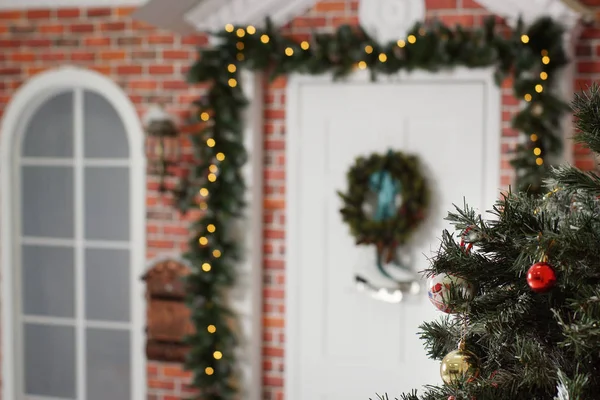Los juguetes de Año Nuevo cuelgan de una rama de abeto en el fondo de la puerta decorada — Foto de Stock
