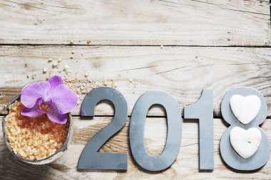 Yeni yıl 2018, ahşap masa, Hindistan cevizi ve banyo tuzu, çiçek orkide ve bir kalp şeklinde beyaz taşların üzerinde spa.