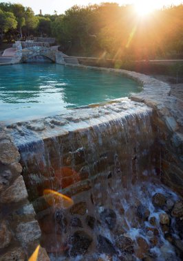 Günbatımında bir çam Parkı içinde yapay şelale