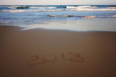 Yeni yıl 2018 gelen bir köpük dalga, yatay ile sahilde kum üzerinde bulunmakta