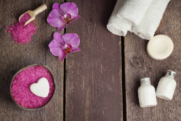 СПА комплект с солью для ванн, орхидеи и полотенцем цветы, лосьон и мыло на деревянном фоне — стоковое фото