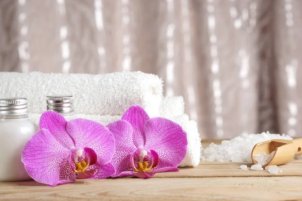 Préparation pour les procédures de spa, sel, serviettes, lotion et fleurs lumineuses d'orchidées sur la table — Photo