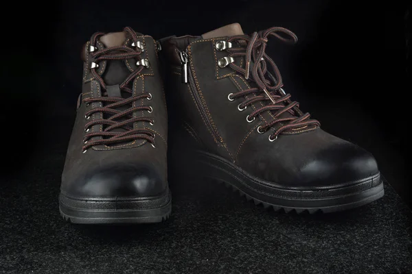 Nové zimní hnědé semišové boty na tmavé žuly. — Stock fotografie