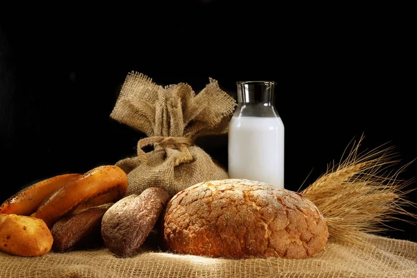натюрморт с яйцами и молоком. depositphotos 191648814 stock photo still life with bread and. натюрморт с яйцами и молоком фото. натюрморт с яйцами и молоком-depositphotos 191648814 stock photo still life with bread and. картинка натюрморт с яйцами и молоком. картинка depositphotos 191648814 stock photo still life with bread and. Стакан молока, буханка и сноп на черном фоне, с местом для текста