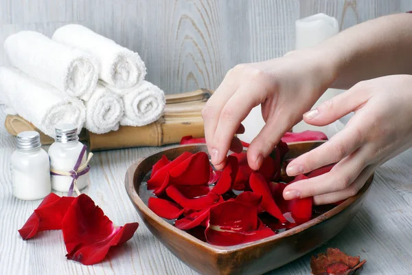 Préparation d'une procédure de spa pour les mains avec pétales de roses rouges et accessoires blancs — Photo