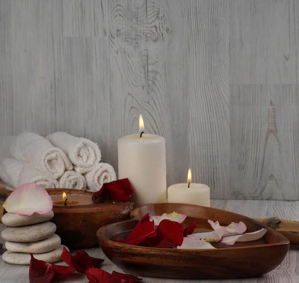 Tratamento de spa de mãos com pétalas de rosa e velas ardentes — Fotografia de Stock