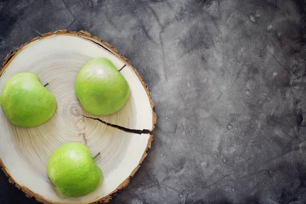 Три половинки зеленых яблок на деревянном стуле на столе, здоровая пища — стоковое фото