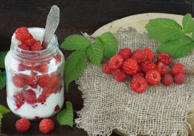 Yoğurtlu kavanoz ve bahçeden olgun ahududu.