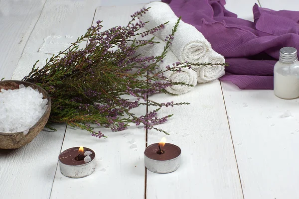 Conjunto para tratamentos de spa e galho de urze jazem em uma mesa de madeira branca — Fotografia de Stock