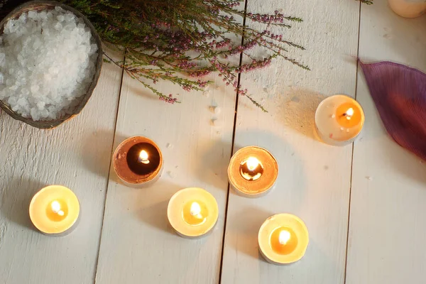 Burning candles and spa set with heather and bath salt on a wooden table — Stock Photo, Image