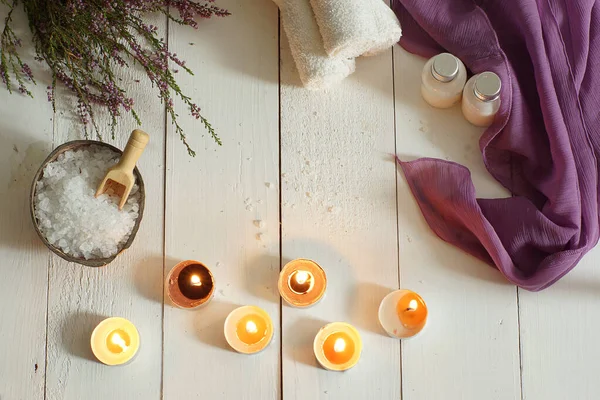 Queimar velas e definir para spa com urze em uma mesa de madeira branca, vista superior — Fotografia de Stock