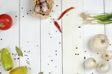 Salata hazırlamak için sebzeler ve baharatlar beyaz ahşap bir masa üzerinde uzanır, üst görünüm, metin için kopyalama alanı