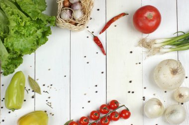 Salata hazırlamak için farklı sebzeler ve baharatlar beyaz tahta bir masanın üzerinde uzanır, üst görünüm, metin için kopyalama alanı