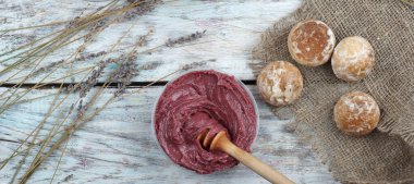 Masadaki koyu kırmızı renkte çırpılmış bal bir buket lavanta ve zencefilli kurabiyenin yanında, üst manzara, panorama